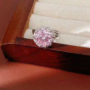 Gros plan d'une bague élégante avec zircon rose et monture tissée argentée raffinée.