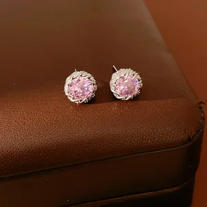 Gros plan de boucles d'oreilles rondes élégantes en zircon rose et bordure argentée