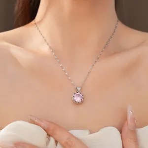 Gros plan d'un pendentif en zircon rose sur un collier argenté porté par un mannequin.