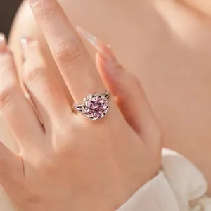 Gros plan d'une bague en argent ornée d'un grand zircon rose rond sur monture florale.