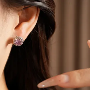 Gros plan d'une élégante boucle d'oreille ronde en zircon rose portée par un mannequin