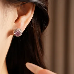 Gros plan détaillé d'une élégante boucle d'oreille ronde en zircon rose avec serti micro-pavé