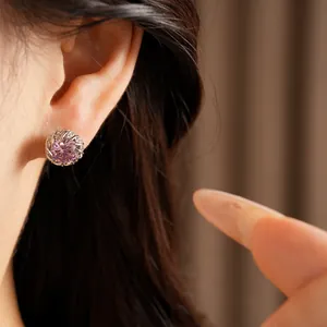Gros plan détaillé montrant une élégante boucle d'oreille en zircon rose sur un modèle