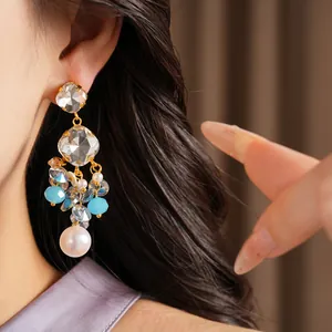 Detail view of elegant vintage geometric glass tassel earrings with blue beads and pearls.