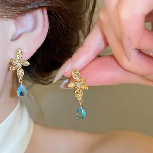 Detailed view of 18k gold plated flower earrings featuring elegant blue teardrop zircon stones