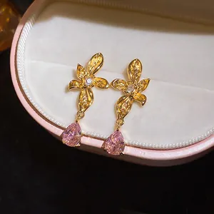 Detailed macro view of floral stud earrings with pink teardrop zircon in a jewelry box