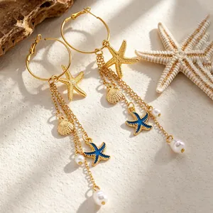 Vue détaillée de boucles d'oreilles bohèmes en forme d'étoile de mer et de coquillage doré