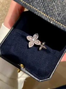 Close-up of a sparkling zircon star flower open ring inside a premium navy blue velvet box.