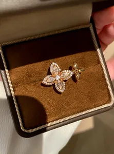 Detailed close-up of a sparkling zircon flower ring presented in a brown velvet box