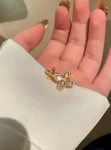 Close-up of an elegant gold flower ring with sparkling zircon stones on a person's hand