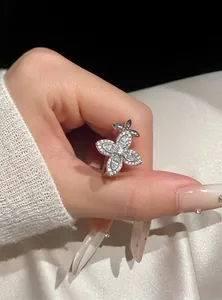 Detailed view of an elegant silver star-flower ring with sparkling zircons on finger