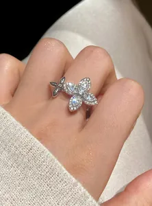 Close-up detail of an elegant silver zircon flower open ring on a woman's finger