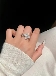 Detailed macro view of an elegant zircon star flower open ring worn on a model's finger.