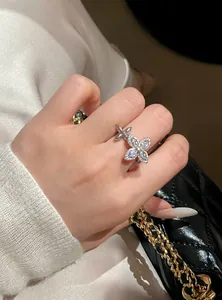 Detailed close-up of an elegant silver zircon star flower open ring worn on a model hand