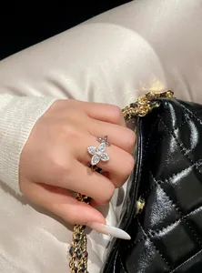 Close-up detail showing the sparkling zircon flower starburst open ring on a hand