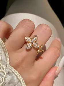 Close-up of a gold-plated star flower ring featuring sparkling zircon stones on a finger