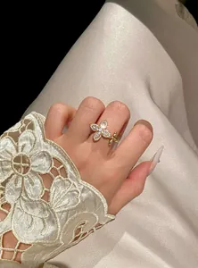 Elegant gold-toned star-flower ring with shimmering zircons worn on an index finger