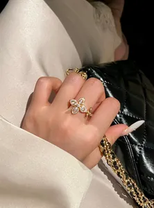 Detailed view of a gold star-flower ring with sparkling zircons on a woman's finger