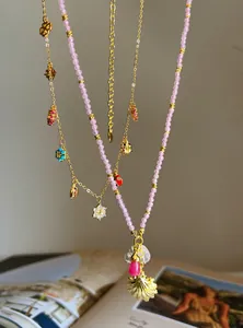 Detail view of colorful charm necklaces and pink beaded shell pendant necklace