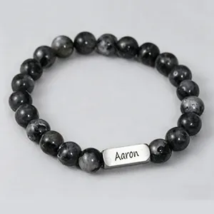 Detailed shot of natural stone beads bracelet with custom engraved metal name tag Aaron