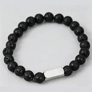 Makroaufnahme von Lavastein-Perlenarmband mit gravierter silberner Noah-Metallplatte