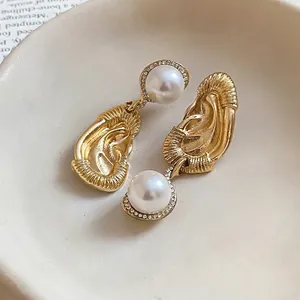 Unique ear-shaped gold earrings with large white pearl drop and crystal accents for women