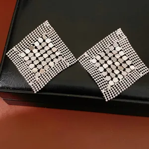 Vue détaillée de boucles d'oreilles géométriques en maille argentée en forme de losange