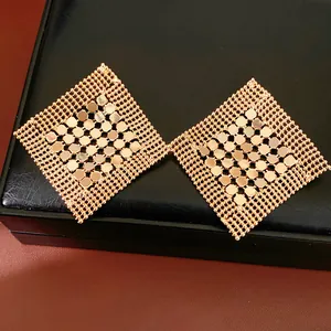 Vue détaillée de boucles d'oreilles géométriques en losange avec maille dorée élégante