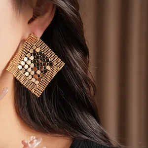 Gros plan de boucles d'oreilles dorées géométriques en forme de losange