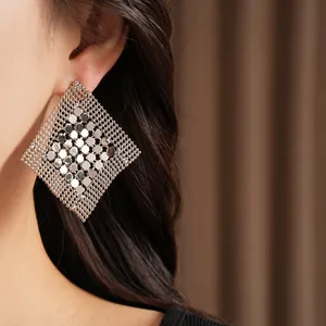 Vue macro montrant la texture complexe du maillage métallique des boucles d'oreilles