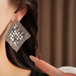 Vue détaillée de boucles d'oreilles géométriques argentées en forme de losange ajouré