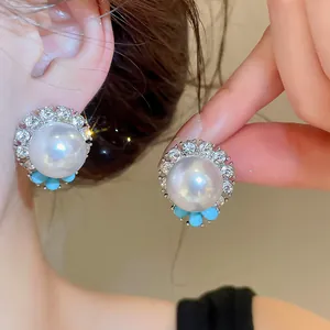 Primo piano di orecchini vintage in perla di resina con dettagli in strass