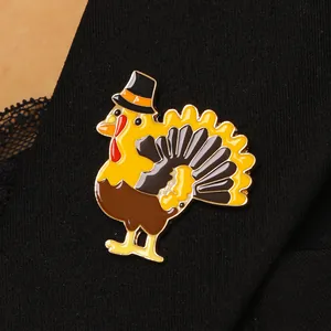 Gros plan d'un pin's en émail dindon coloré sur tissu noir pour le Thanksgiving.