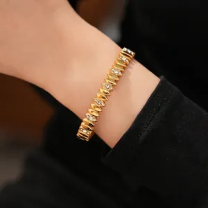 Elegant gold stainless steel bracelet with clear zircon stones on female model's wrist