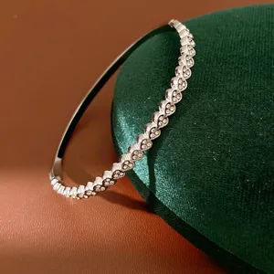 Macro view of silver-toned stainless steel heart-link bracelet with cubic zirconia