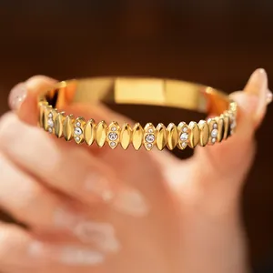 Detailed view of gold stainless steel bracelet with zircon inlay and oval pattern.