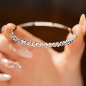 Close-up of silver stainless steel heart-shaped bangle with sparkling zircon stones.