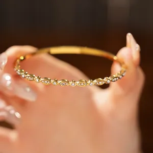 Close-up detail of gold stainless steel bangle featuring marquise zircon settings.