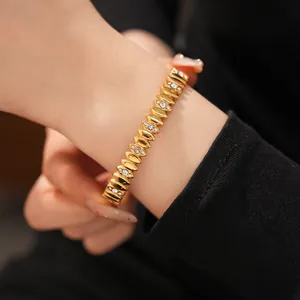 Close-up view of a gold stainless steel bracelet with sparkling zircon accents on wrist