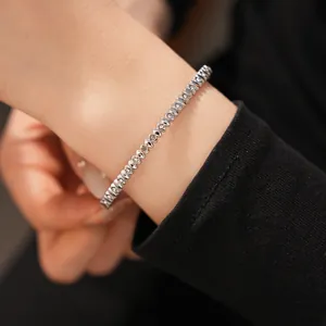 Detailed view of minimalist silver stainless steel bracelet with sparkling cubic zirconia on wrist