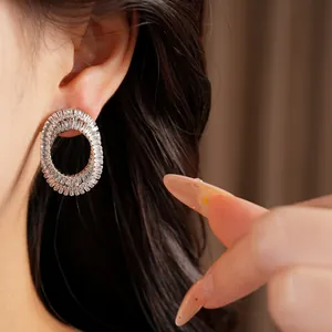 Detail view of silver needle oval stud earrings with brilliant pavé zircon stones.