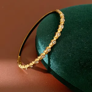 Detailed close-up of a gold stainless steel bangle with sparkling round zircons