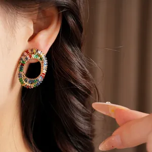 Detail view of vibrant colorful baguette-cut zircon oval earrings worn on the ear