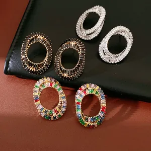 Detailed close-up view of oval crisscross stud earrings featuring colorful and black zircons