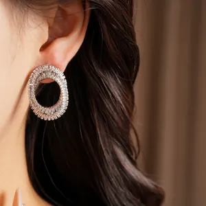 Close-up detail of luxury oval crossed stud earrings inlaid with sparkling zircons