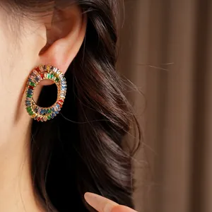 Detail shot of elegant oval earrings encrusted with multi-colored zircon crystals