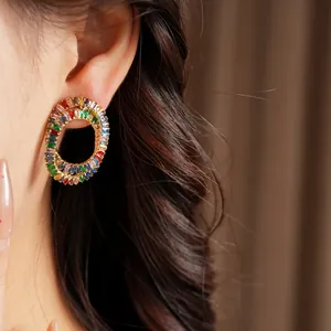 Detailed view of elegant multi-color zircon oval stud earrings worn on a model ear