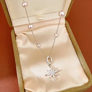 Elegant starburst pendant necklace with pink pearls and zircon in a jewelry box display