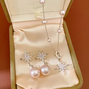 Detailed view of pearl star necklace and earrings set in an elegant jewelry box.