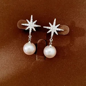 Close-up view of elegant starburst earrings with pave zircon and pink pearls